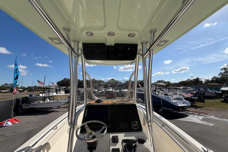 Slide: The Image of 2025 Bulls Bay 255 Center Console boat interior with steering wheel and dashboard, under sunny sky. - 27