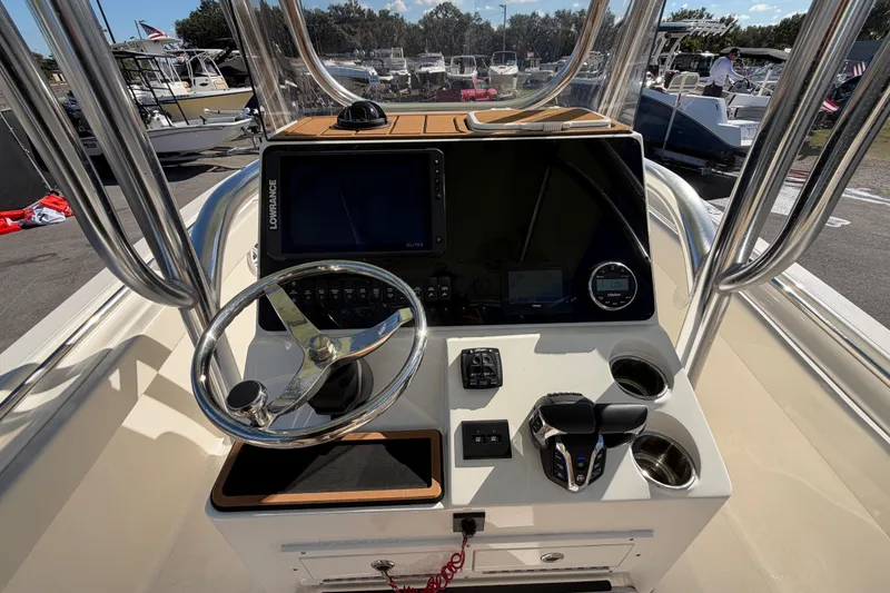 Slide: The Image of 2025 Bulls Bay 255 Center Console boat dashboard with steering wheel and navigation controls. - 28