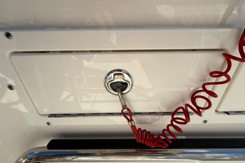 Slide: The Image of 2025 Bulls Bay 255 Center Console dashboard with red safety lanyard and storage compartments. - 38