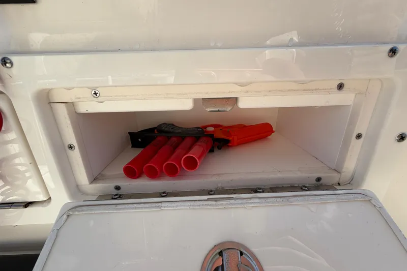 Slide: The Image of 2025 Bulls Bay 255 Center Console storage compartment with chrome handle and secure latch. - 41