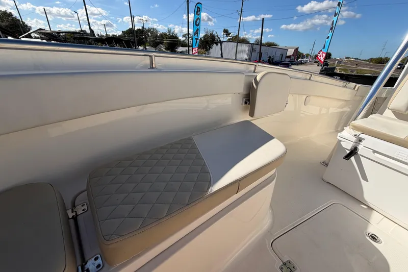Slide: The Image of 2025 Bulls Bay 255 Center Console boat interior with seating and storage, displayed outdoors. - 64