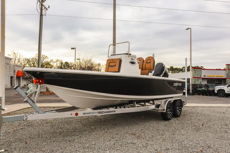 The Image of 2026 Sea Pro 210 Bay boat on trailer, parked outdoors, overcast sky. - 0