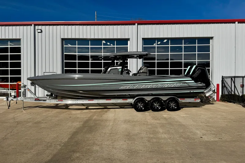 Slide: The Image of 2026 Sunsation 32 CCX boat on trailer, parked outside a building. - 1