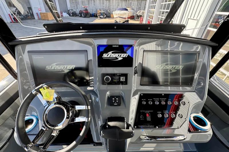 Slide: The Image of 2026 Sunsation 32 CCX boat dashboard with dual Garmin displays and modern controls. - 13