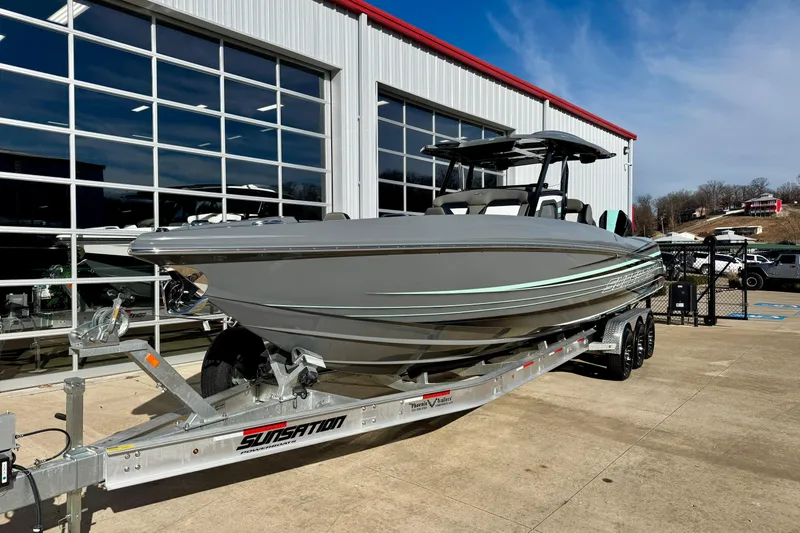 Slide: The Image of 2026 Sunsation 32 CCX boat on trailer outside a showroom. - 2