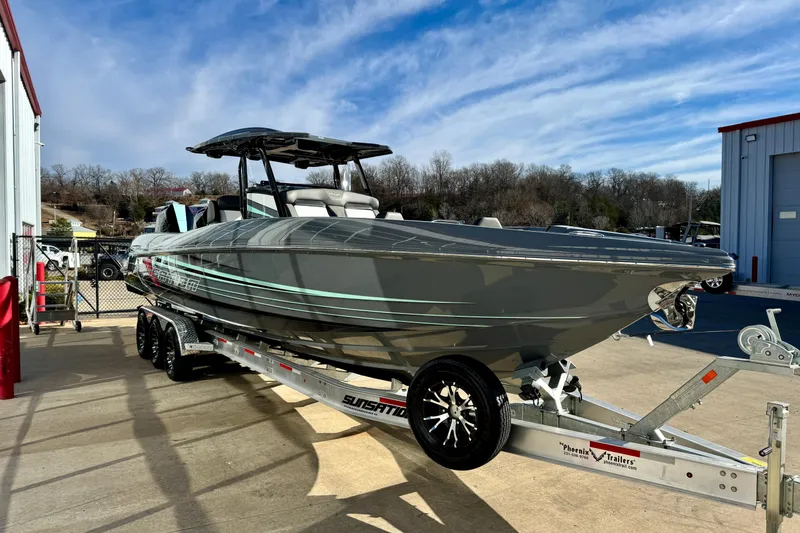 Slide: The Image of 2026 Sunsation 32 CCX boat on trailer, parked outdoors under blue sky. - 4