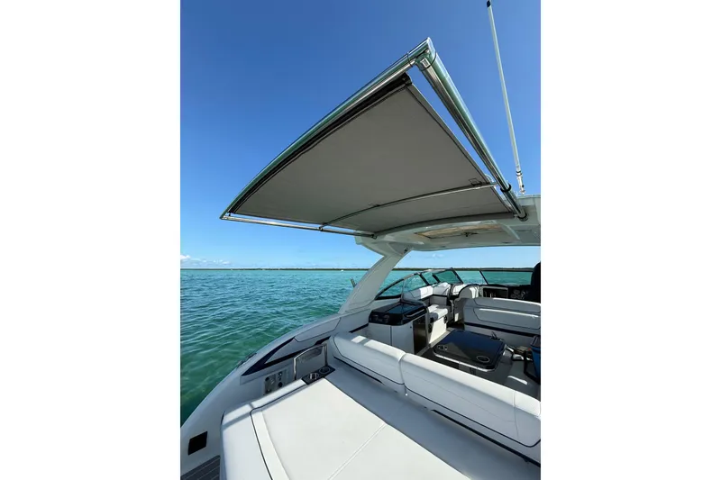 Slide: The Image of 2022 Formula 350 Crossover Bowrider OB with sunshade, cruising on clear blue waters. - 15