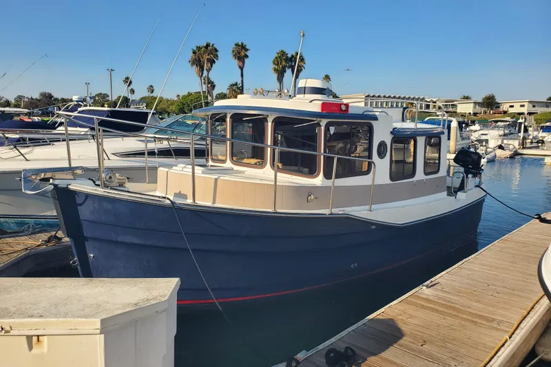 Slide: The Image of 2008 Ranger Tugs R-25 boat docked at marina with clear blue sky. - 1