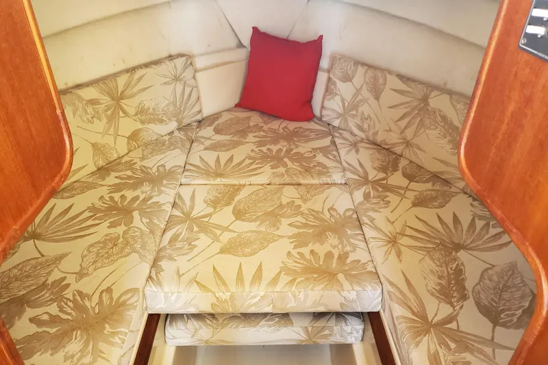 Slide: The Image of 2008 Ranger Tugs R-25 cabin interior with floral-patterned cushions and a red pillow. - 12