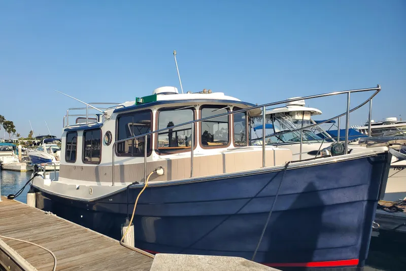 Slide: The Image of 2008 Ranger Tugs R-25 boat docked at marina under clear blue sky. - 2