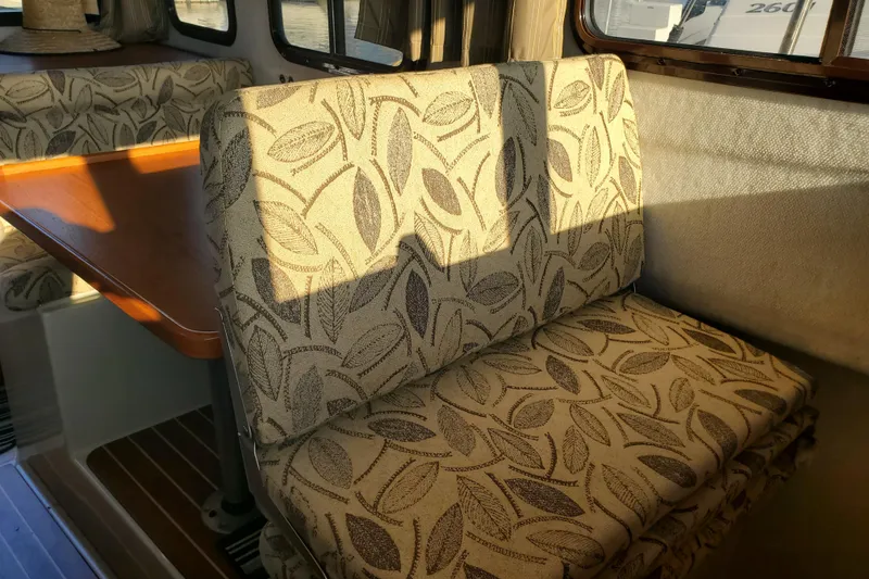 Slide: The Image of Interior of 2008 Ranger Tugs R-25 with patterned seating and wooden table. - 5