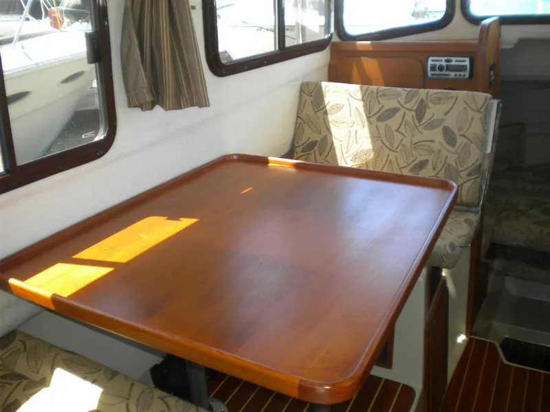Slide: The Image of Interior of 2008 Ranger Tugs R-25 with wooden table and cushioned seats. - 6