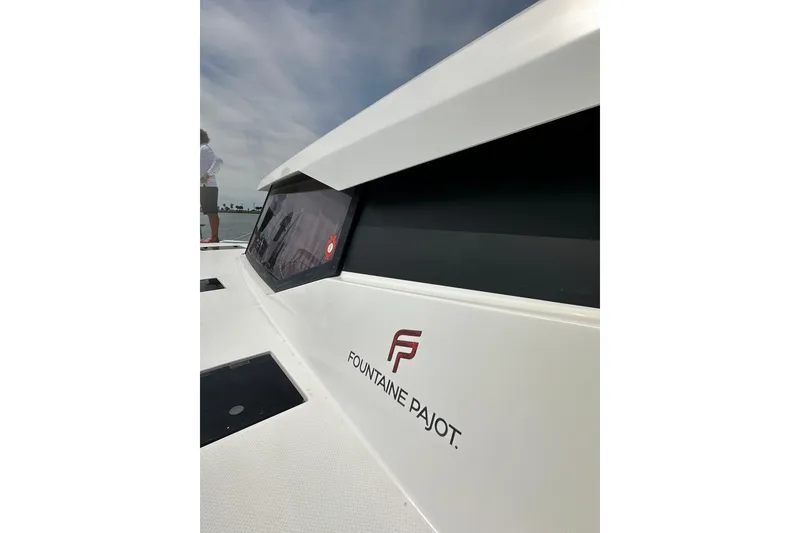 Slide: The Image of 2020 Fountaine Pajot Astrea 42 Catamaran, sleek design with logo, docked under clear sky. - 28