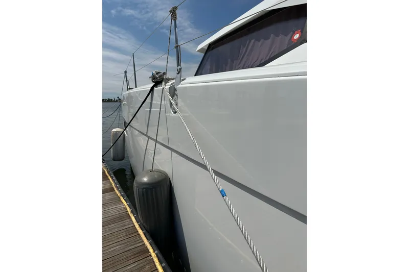 Slide: The Image of 2020 Fountaine Pajot Astrea 42 Catamaran docked, showing side view with ropes and fenders. - 29