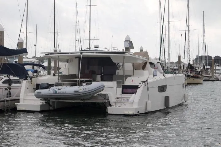 Slide: The Image of 2020 Fountaine Pajot Astrea 42 Catamaran docked in a marina with inflatable boat. - 3
