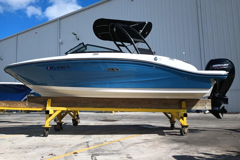 Slide: The Image of 2023 Sea Ray SPX 190 Outboard boat on stand, blue hull, Mercury engine. - 0