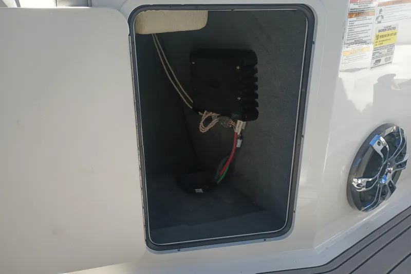 Slide: The Image of 2023 Sea Ray SPX 190 Outboard storage compartment with wiring and speaker detail. - 19