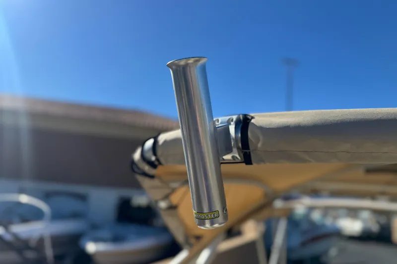 Slide: The Image of 2013 Bennington 2575QCW I/O boat with a metal rod holder under a clear blue sky. - 11