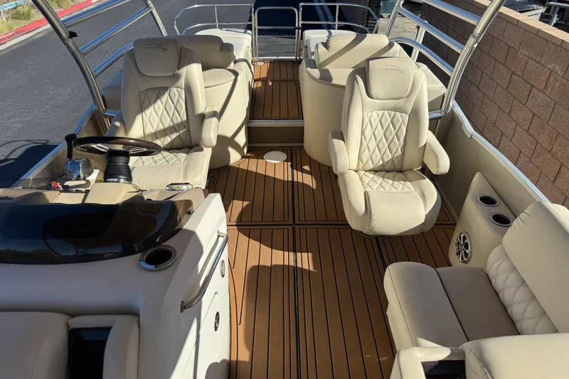 Slide: The Image of 2013 Bennington 2575QCW I/O boat interior with beige seating and wooden flooring. - 19