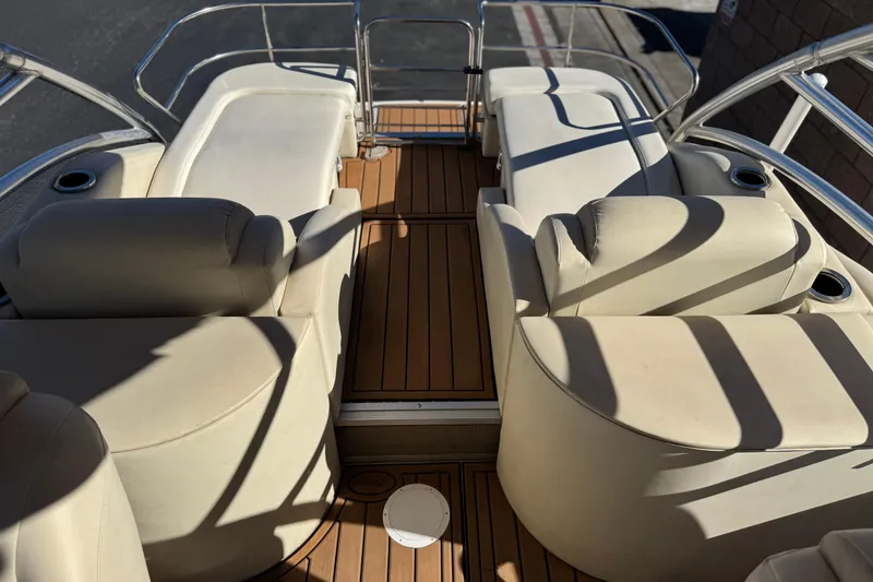 Slide: The Image of Interior of 2013 Bennington 2575QCW I/O boat with beige seating and wooden flooring. - 22