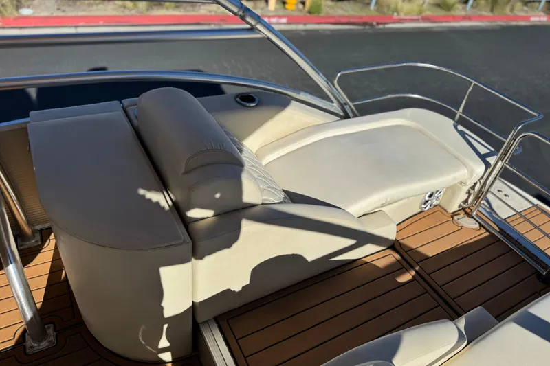 Slide: The Image of 2013 Bennington 2575QCW I/O boat interior with beige seating and wooden deck. - 23