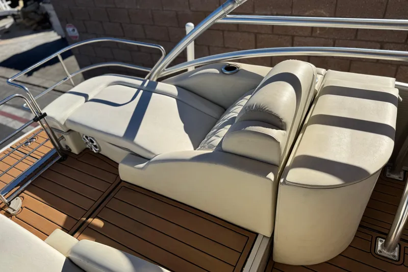 Slide: The Image of 2013 Bennington 2575QCW I/O boat with beige seating and wooden deck. - 24
