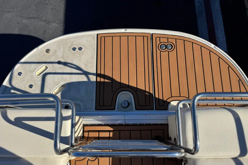 Slide: The Image of 2013 Bennington 2575QCW I/O boat deck with wood finish and metal railings. - 26