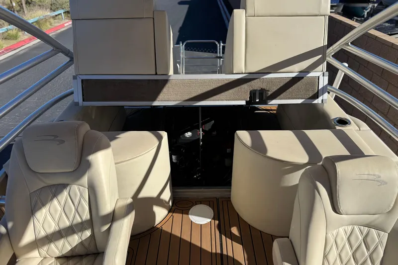 Slide: The Image of 2013 Bennington 2575QCW I/O boat interior with beige seating and wood flooring. - 28