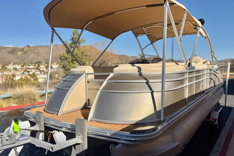 Slide: The Image of 2013 Bennington 2575QCW I/O pontoon boat on trailer, scenic background. - 3