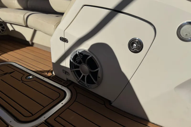 Slide: The Image of 2013 Bennington 2575QCW I/O boat interior with speaker and teak flooring. - 35