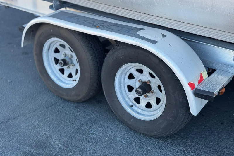 Slide: The Image of Trailer wheels of a 2013 Bennington 2575QCW I/O boat on pavement. - 36