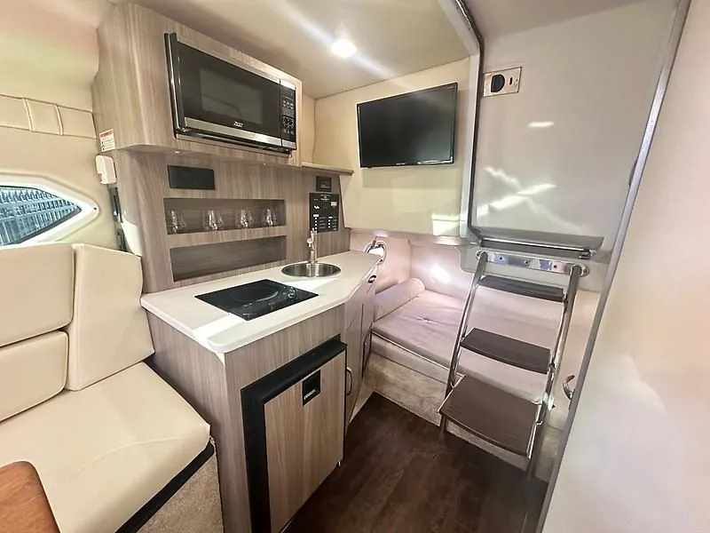 Slide: The Image of 2021 Regal 26 XO boat interior with kitchen and seating area. - 26