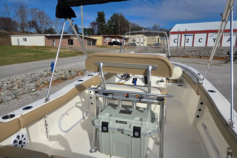 Slide: The Image of 2015 Key West 203 FS boat interior with seating and storage, parked on gravel. - 12