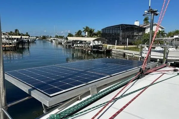 Slide: The Image of Lagoon 440 catamaran (2006) with solar panels docked in a scenic marina. - 10