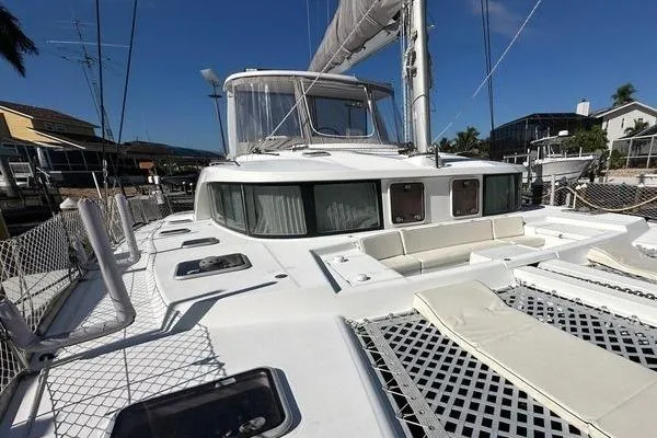 Slide: The Image of 2006 Lagoon 440 catamaran with spacious deck and netting, docked in a marina. - 11