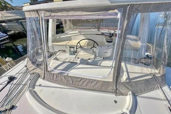 Slide: The Image of 2006 Lagoon 440 catamaran cockpit with clear enclosure and steering wheel. - 14