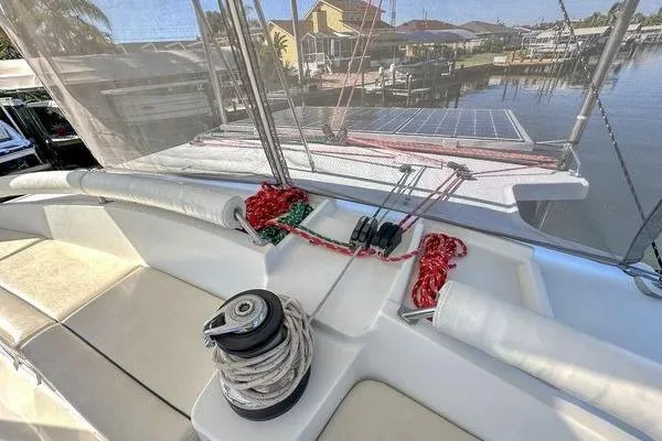 Slide: The Image of Deck view of 2006 Lagoon 440 catamaran with ropes and winch, docked near waterfront homes. - 15