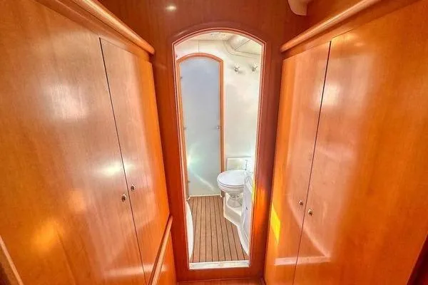 Slide: The Image of Interior of 2006 Lagoon 440 yacht featuring wooden cabinetry and a compact bathroom. - 20