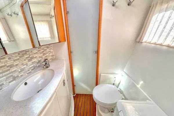 Slide: The Image of Bathroom interior of 2006 Lagoon 440 catamaran with sink, toilet, and shower. - 21