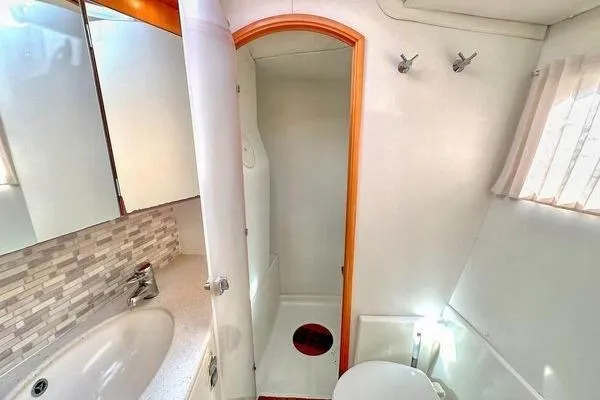 Slide: The Image of Bathroom interior of 2006 Lagoon 440 catamaran with shower, sink, and toilet. - 23