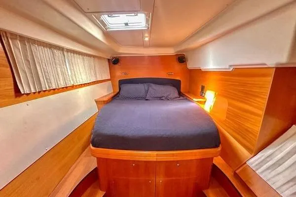 Slide: The Image of Interior cabin of 2006 Lagoon 440 catamaran with cozy bed and wooden finish. - 27