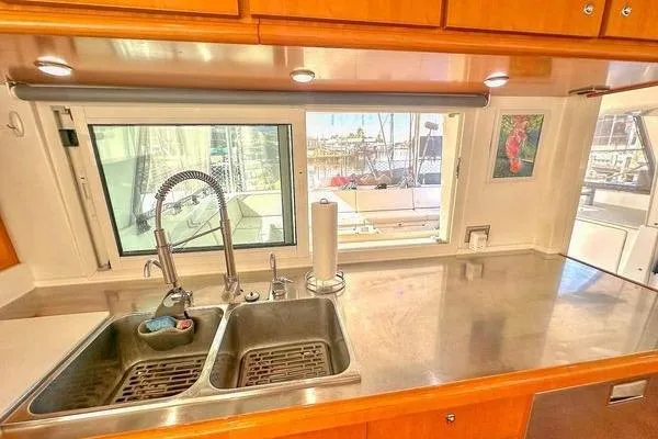 Slide: The Image of Galley kitchen in 2006 Lagoon 440 catamaran with stainless steel sink and window view. - 32