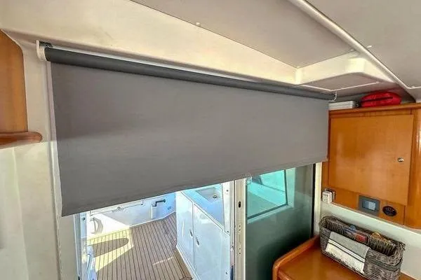 Slide: The Image of Interior of 2006 Lagoon 440 yacht with gray window shade and wooden cabinetry. - 33