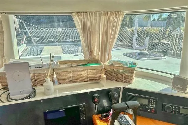 Slide: The Image of Interior view of 2006 Lagoon 440 catamaran cockpit with navigation equipment and wicker baskets. - 34