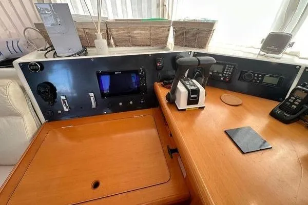 Slide: The Image of Control panel of a 2006 Lagoon 440 catamaran with navigation equipment and communication devices. - 38