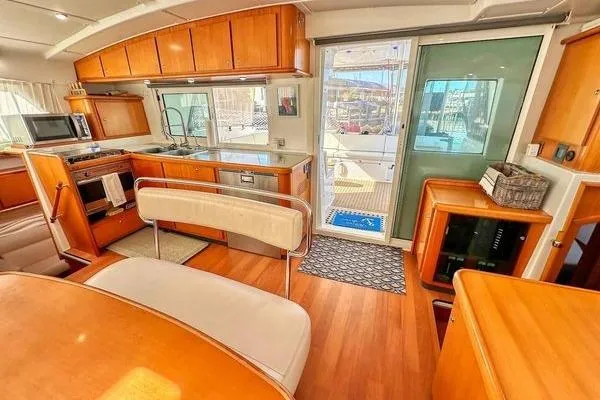 Slide: The Image of Interior of 2006 Lagoon 440 catamaran with modern kitchen and wooden furnishings. - 41