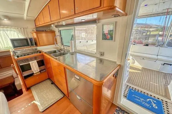Slide: The Image of Interior of 2006 Lagoon 440 yacht kitchen with modern appliances and wooden cabinetry. - 43