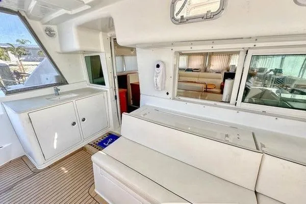 Slide: The Image of Interior of 2006 Lagoon 440 catamaran with white seating and cabinetry. - 47