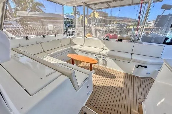 Slide: The Image of Spacious deck of 2006 Lagoon 440 catamaran with comfortable seating and wooden table. - 49