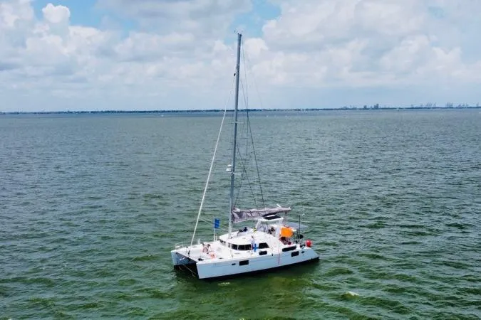 Slide: The Image of 2006 Lagoon 440 catamaran sailing on open water under a cloudy sky. - 6
